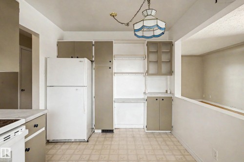 Kitchen featuring built-in cabinetry, patterned flooring, and a pass-through opening - 9723 76 Street Nw, Edmonton, AB - Indoor Photo Showing Kitchen