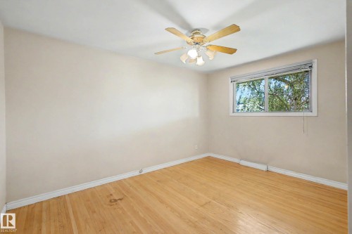 Hardwood flooring, white trim, single window, white walls, and a ceiling fan with integrated lighting - 9723 76 Street Nw, Edmonton, AB - Indoor Photo Showing Other Room