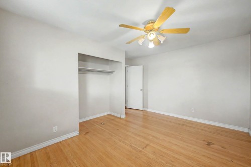 Wood-finish flooring with white walls - 9723 76 Street Nw, Edmonton, AB - Indoor Photo Showing Other Room