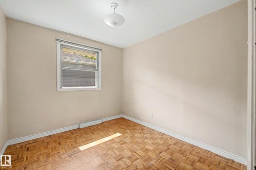 Parquet wood flooring, a single window, and a flush mount ceiling light - 9723 76 Street Nw, Edmonton, AB - Indoor Photo Showing Other Room