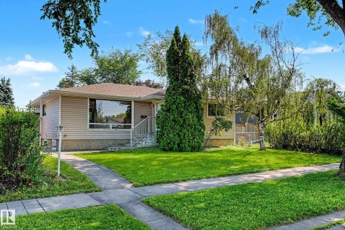 Manicured front lawn with mature trees and established landscaping - 9723 76 Street Nw, Edmonton, AB - Outdoor