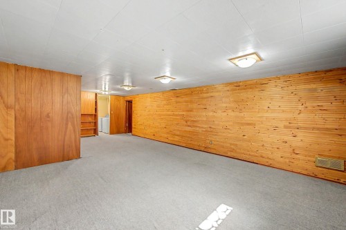 Expansive room with carpet flooring, wood paneling, and built-in shelving - 9723 76 Street Nw, Edmonton, AB - Indoor Photo Showing Other Room