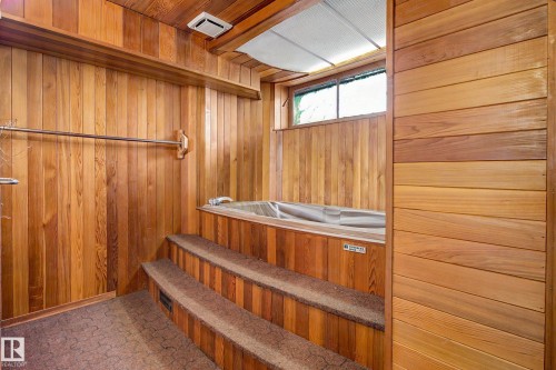 Wood-paneled room with an integrated hot tub, multi-tiered steps with carpeted treads, and a transom window - 9723 76 Street Nw, Edmonton, AB - Indoor Photo Showing Other Room