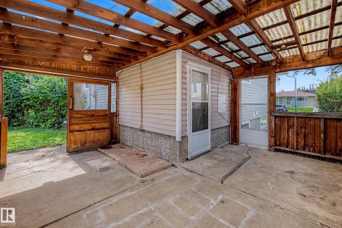 Covered concrete patio with exposed wood beams and corrugated translucent roof panels - 9723 76 Street Nw, Edmonton, AB - Outdoor With Exterior