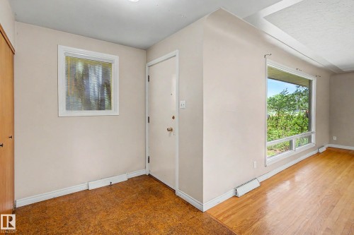 Hardwood flooring, front entry door, textured glass window, and large picture window - 9723 76 Street Nw, Edmonton, AB - Indoor Photo Showing Other Room