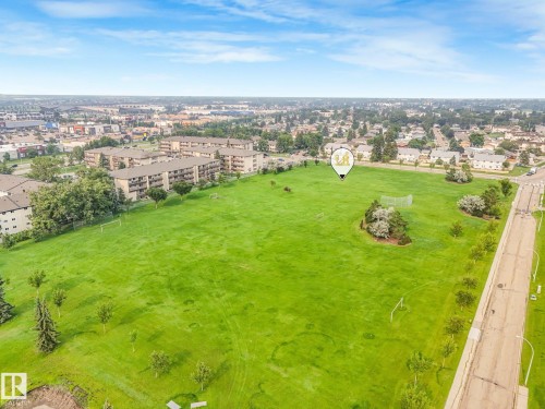 Expansive green space featuring scattered trees and a paved street bordering the property - 4135 134 Avenue Nw, Edmonton, AB - Outdoor With View