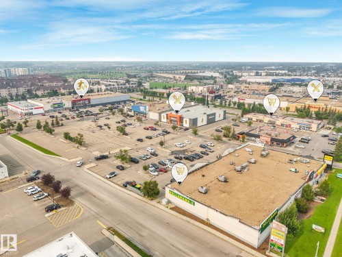 Aerial perspective showcasing a commercial development with multiple retail establishments, extensive paved parking areas, and surrounding businesses - 4135 134 Avenue Nw, Edmonton, AB - Outdoor With View