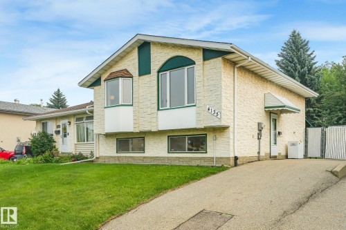 Split-level residence featuring a textured stucco exterior with green trim accents and a partial stone facade - 4135 134 Avenue Nw, Edmonton, AB - Outdoor