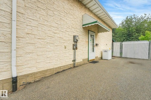 Textured stucco exterior with a decorative green and white awning over a glass-paneled door - 4135 134 Avenue Nw, Edmonton, AB - Outdoor With Exterior