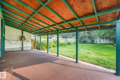 Covered patio featuring a wood-panel ceiling supported by green beams and posts - 4135 134 Avenue Nw, Edmonton, AB - 