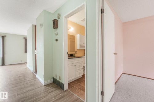 Compact bathroom featuring a single vanity with white cabinetry, dark countertop, and overhead lighting - 4135 134 Avenue Nw, Edmonton, AB - Indoor Photo Showing Other Room