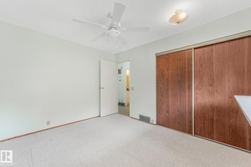 Bedroom featuring light-colored carpeting, a white ceiling fan, and a flush-mount ceiling fixture - 4135 134 Avenue Nw, Edmonton, AB - Indoor Photo Showing Other Room