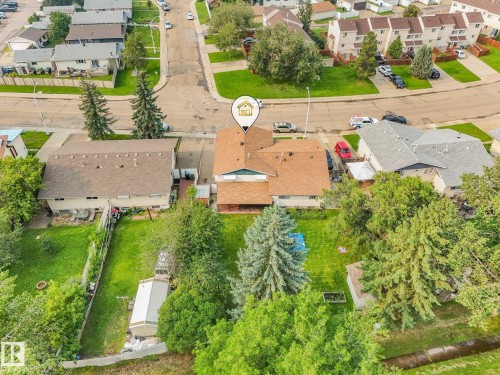 Aerial perspective of a property featuring a residential structure with a brown shingle roof, surrounded by mature trees and green landscaping - 4135 134 Avenue Nw, Edmonton, AB - Outdoor With View