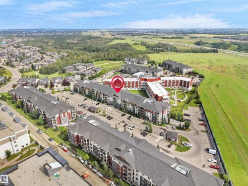 Multi-story residential buildings featuring gabled roofs and individual balconies - #205 5816 Mullen Pl Nw, Edmonton, AB - Outdoor With View