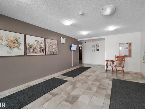 Tiled flooring throughout the common area - #205 5816 Mullen Pl Nw, Edmonton, AB - Indoor Photo Showing Other Room