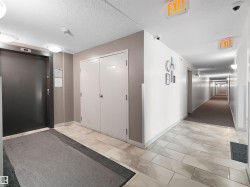Elevator access, tile flooring, flush-mounted ceiling lights, and hallway with wall sconces - 