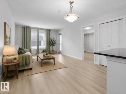 Recessed lighting, wood-finish flooring, white trim, and a white interior door with dark hardware - 