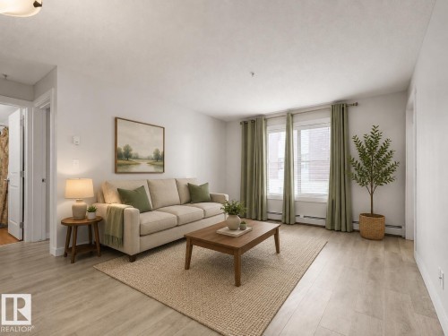 Light wood-finish flooring, white walls, and a multi-pane window with white blinds - #205 5816 Mullen Pl Nw, Edmonton, AB - Indoor Photo Showing Living Room