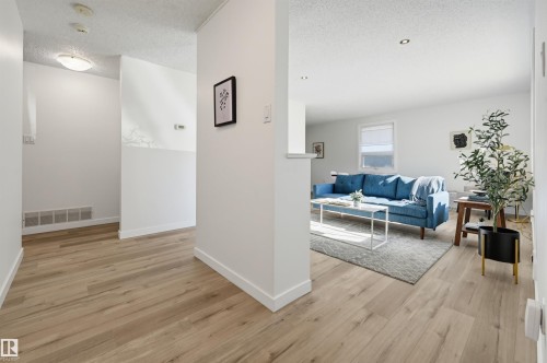 Wood-finish flooring throughout, white walls, and recessed lighting in the living area - 9127 149 Street Nw, Edmonton, AB - Indoor