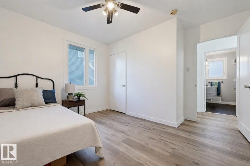 Wood-finish flooring, ceiling fan, white window frames, and white walls - 9127 149 Street Nw, Edmonton, AB - Indoor Photo Showing Bedroom