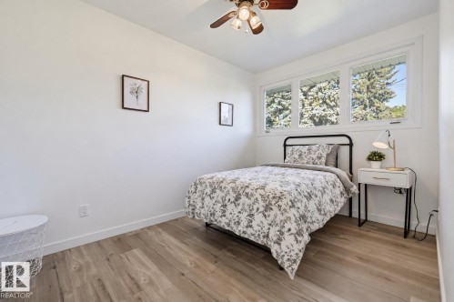 Wood-finish flooring with white baseboards - 9127 149 Street Nw, Edmonton, AB - Indoor Photo Showing Bedroom