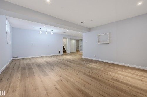 Spacious room featuring wood-finish flooring, recessed lighting, and a window - 9127 149 Street Nw, Edmonton, AB - Indoor Photo Showing Other Room