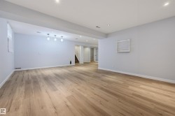 Spacious room featuring wood-finish flooring, recessed lighting, and a window - 
