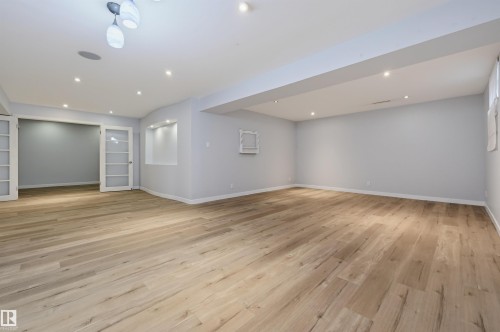 Expansive room featuring wood-finish flooring, recessed lighting, and a built-in wall niche - 9127 149 Street Nw, Edmonton, AB - Indoor Photo Showing Other Room