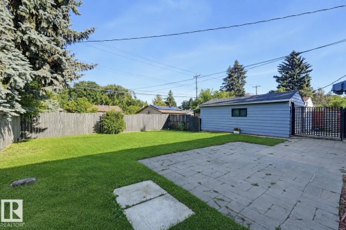 Expansive backyard featuring a lush lawn, privacy fencing, and a paver patio - 9127 149 Street Nw, Edmonton, AB - Outdoor