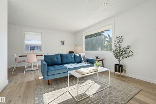 Recessed lighting, wood-finish flooring, white trim, and ample natural light from large windows - 9127 149 Street Nw, Edmonton, AB - Indoor Photo Showing Living Room