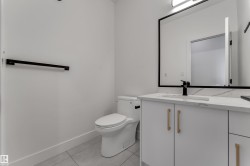 White vanity with gold-finish hardware, rectangular undermount sink, and a black-framed mirror - 