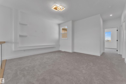 Plush grey carpeting, built-in shelving, white walls, modern ceiling light fixture, and a window with horizontal blinds - 764 Astoria Way, Devon, AB - Indoor Photo Showing Other Room