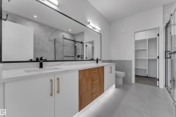 Dual vanity with white cabinetry and wood-finish drawer bank - 