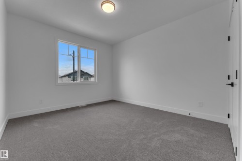 Neutral wall color, grey carpeting, a multi-pane window, and a flush mount ceiling light - 764 Astoria Way, Devon, AB - Indoor Photo Showing Other Room