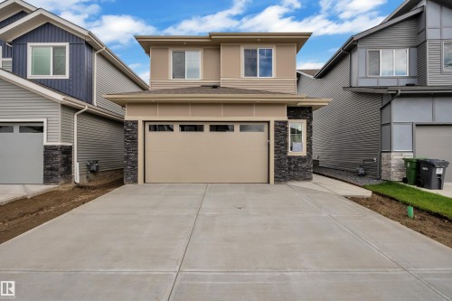 Contemporary two-story exterior featuring a single-car garage, concrete driveway, stone facade accents, and horizontal siding - 764 Astoria Way, Devon, AB - Outdoor