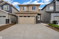 Contemporary two-story exterior featuring a single-car garage, concrete driveway, stone facade accents, and horizontal siding - 