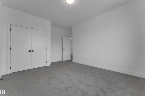 Neutral wall paint, plush carpeting, white trim, and a ceiling light fixture - 764 Astoria Way, Devon, AB - Indoor Photo Showing Other Room