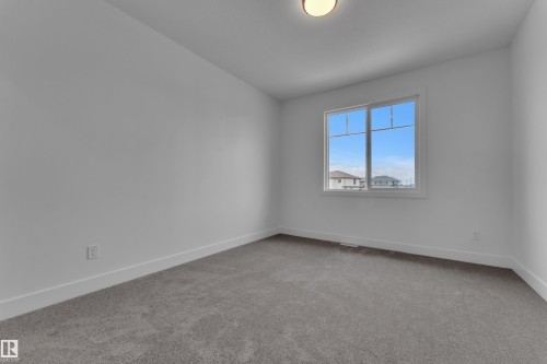 Neutral wall paint, gray carpet flooring, white trim, and a window with white framing - 764 Astoria Way, Devon, AB - Indoor Photo Showing Other Room