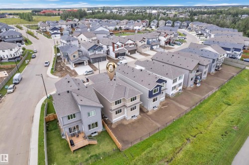 Newly constructed property featuring a multi-level structure with a gabled roof, rear deck, and fenced yard - 764 Astoria Way, Devon, AB - Outdoor With View