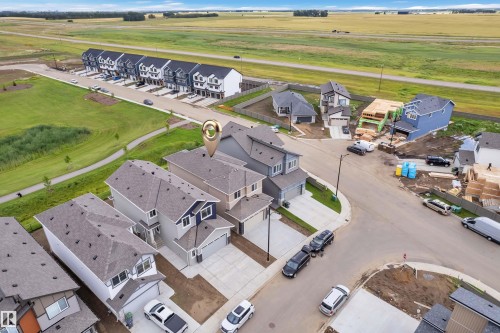 Two-story residential structure with an attached garage, paved driveway, and gabled rooflines - 764 Astoria Way, Devon, AB - Outdoor With Body Of Water With View