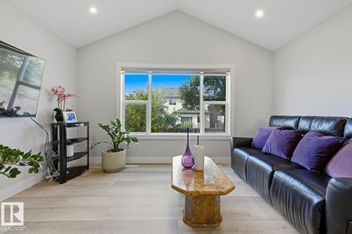 Vaulted ceiling with recessed lighting, large window with white trim, and wood-finish flooring - 11816 168 Avenue Nw, Edmonton, AB - Indoor Photo Showing Living Room
