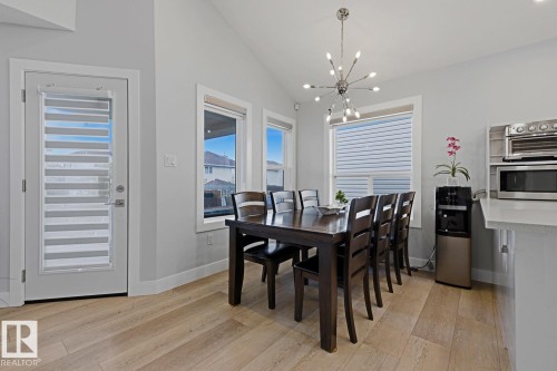 Vaulted ceiling, wood-finish flooring, multiple windows, contemporary light fixture, and built-in microwave - 11816 168 Avenue Nw, Edmonton, AB - Indoor Photo Showing Dining Room