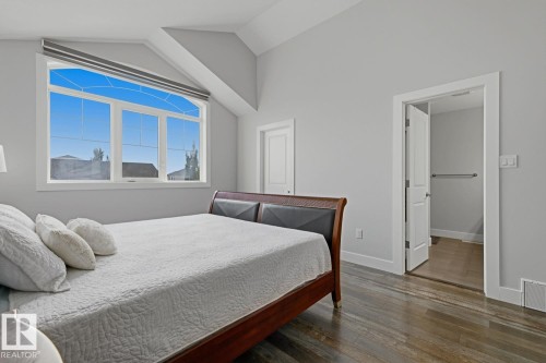Vaulted ceiling, large picture window with transom, wood-finish flooring, and a white interior door - 11816 168 Avenue Nw, Edmonton, AB - Indoor Photo Showing Bedroom