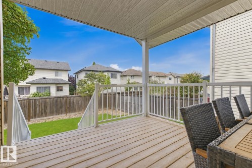 Covered deck with wood-finish flooring, white railings, and a direct walk-out to a grassy area - 11816 168 Avenue Nw, Edmonton, AB - Outdoor With Deck Patio Veranda With Exterior
