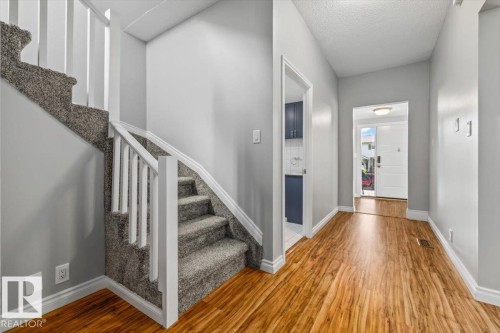 Wood-finish flooring extending from the entry to the hallway - 11429 64 Street Nw, Edmonton, AB - Indoor Photo Showing Other Room