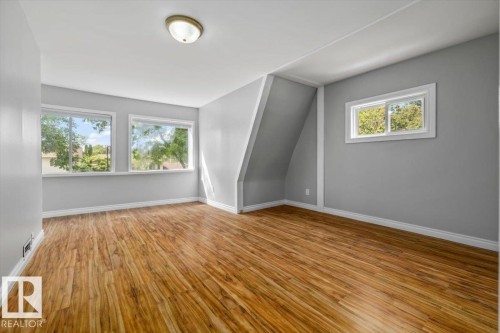 Wood-finish flooring with light gray wall tones and white trim - 11429 64 Street Nw, Edmonton, AB - Indoor Photo Showing Other Room