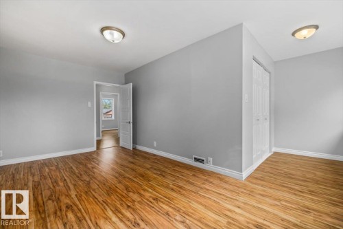 Wood-finish flooring, light gray wall tones, ceiling-mounted lighting, and white trim - 11429 64 Street Nw, Edmonton, AB - Indoor Photo Showing Other Room