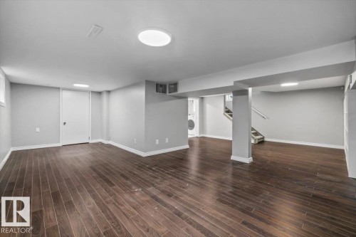 Spacious lower-level room featuring wood-finish flooring, recessed lighting, and a neutral color palette - 11429 64 Street Nw, Edmonton, AB - Indoor Photo Showing Other Room