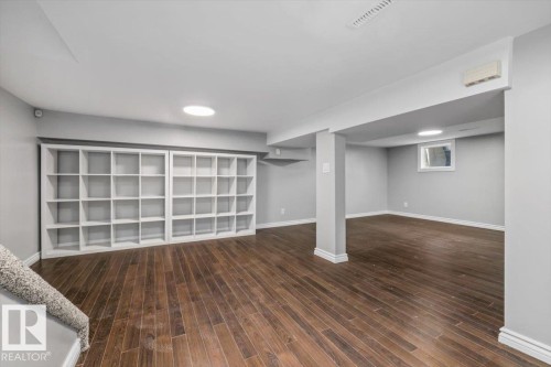 Expansive room featuring wood-finish flooring, built-in shelving, and recessed lighting - 11429 64 Street Nw, Edmonton, AB - Indoor