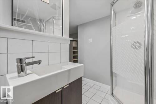 Contemporary vanity with an integrated basin, chrome faucet, and wood-finish cabinetry - 11429 64 Street Nw, Edmonton, AB - Indoor Photo Showing Bathroom